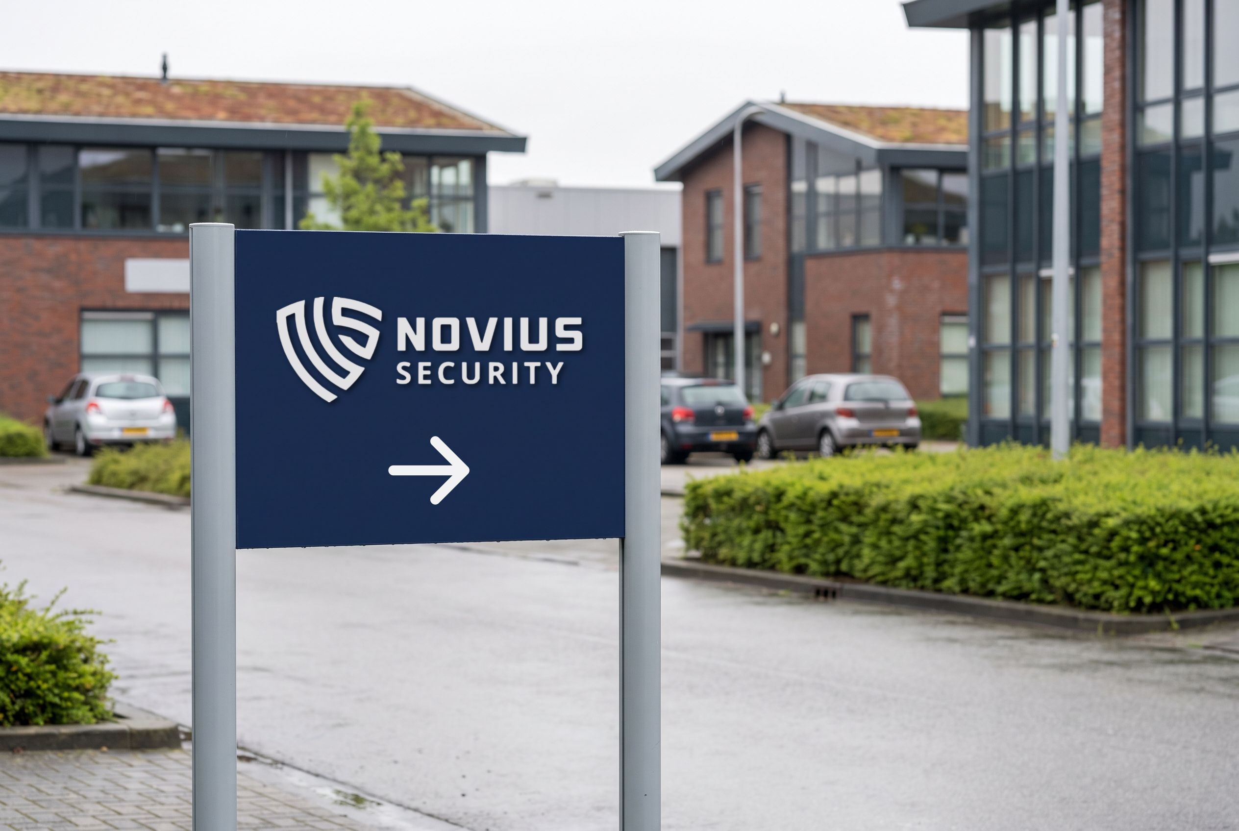 Wegwijzer met het logo van Novius Security en een pijl op een bedrijventerrein