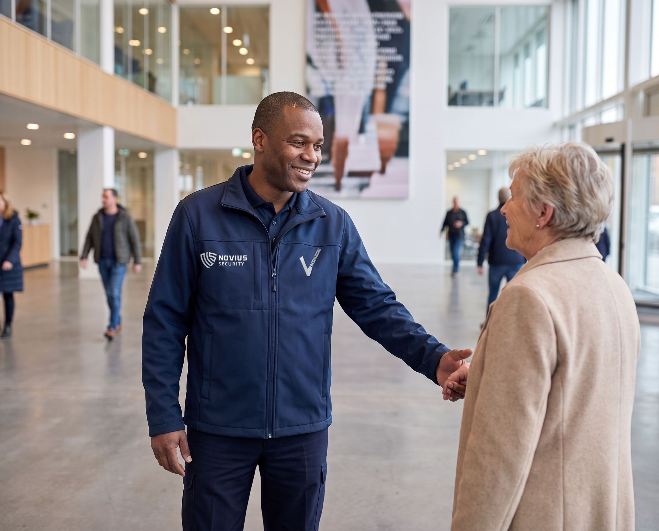 Beveiliger helpt een bezoeker de weg te vinden in een lichte hal