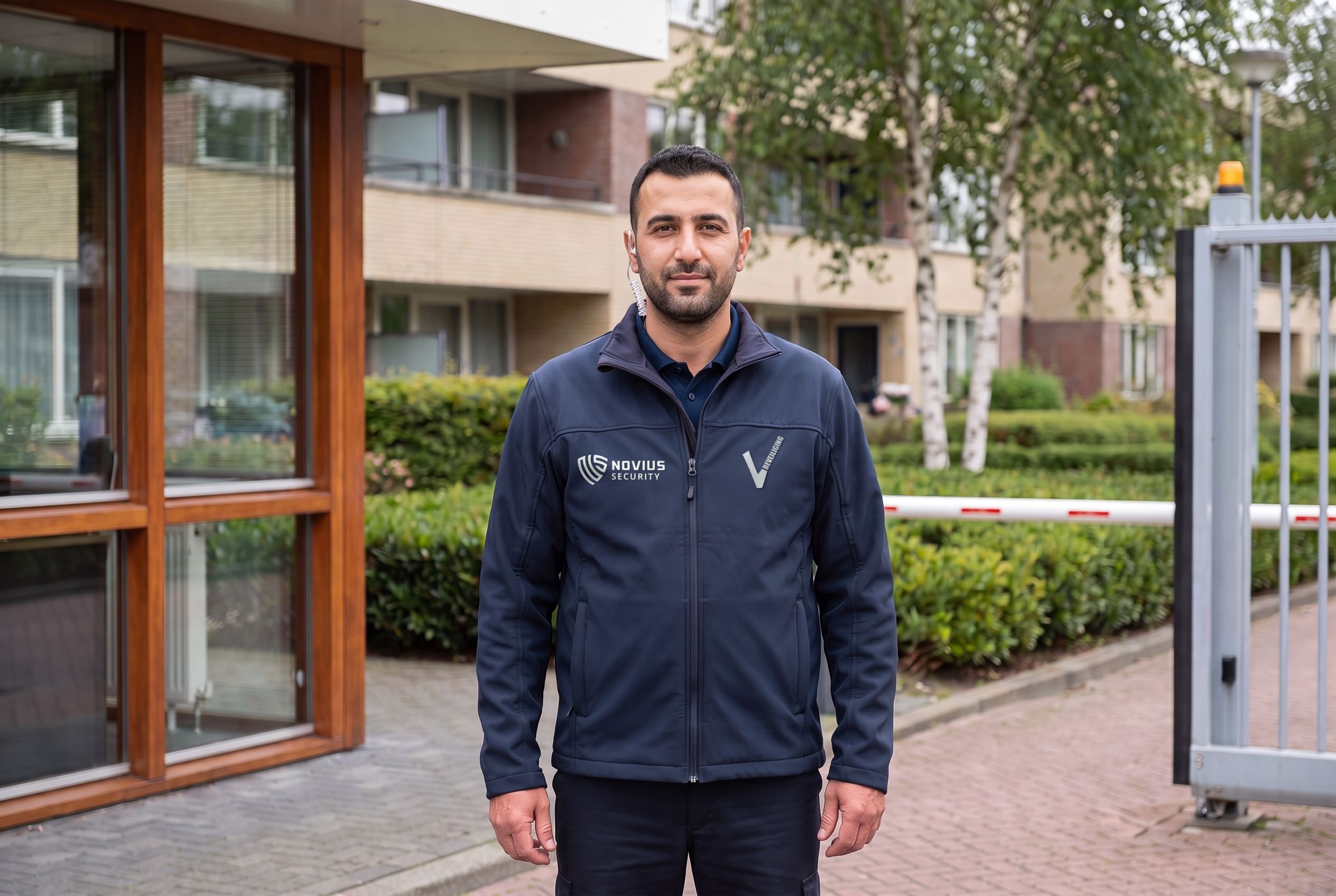 Beveiliger bij het hek van een opvanglocatie